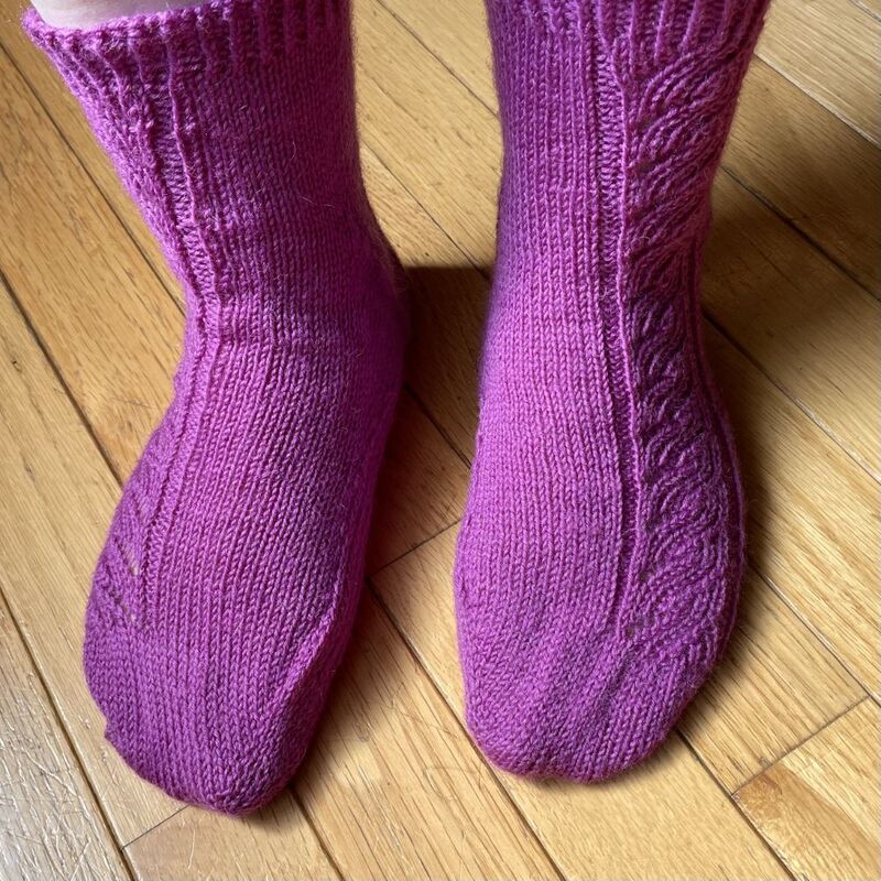 Socks delivered to my first raffle winner.  A simple asymmetric mock cable design in purple.