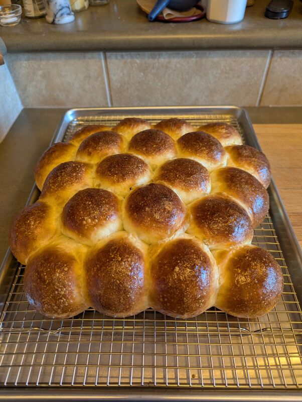 A tray of golden brown, homemade dinner rolls.